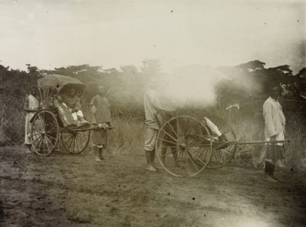Rickshaw pullers in Uganda. African servants pull rickshaws along a muddy track. Frederick Stanbury