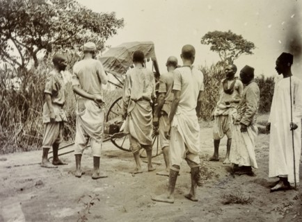 Broken rickshaw, Uganda. A group of African servants consider what to do with rickshaw that has