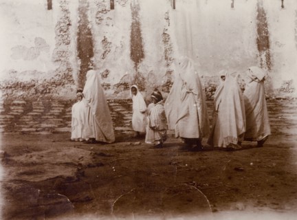 Moroccan women and children. Moroccan women shrouded in robes and headscarves marshal their
