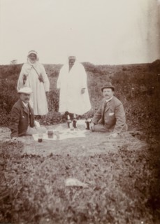 Picnic lunch, Morocco. Two European men enjoy a picnic on a blanket in an open field: their