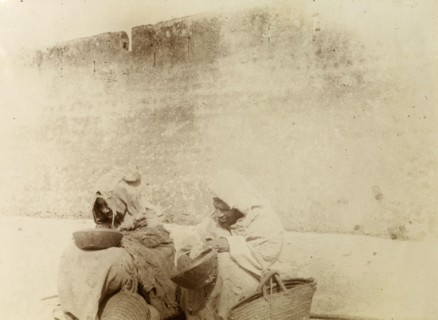 Moroccan beggars. Moroccan beggars dressed in ragged robes, sit on the street, begging bowls and
