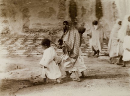 Morrocan woman and children. A young Moroccan woman, her head covered with a scarf, marshals her