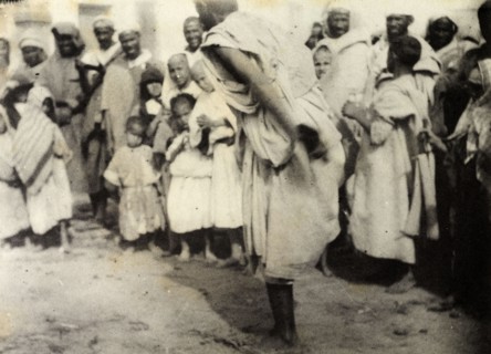 Storytelling at Safi. A 'halaiqui' (storyteller) hops on one leg as he entertains a 'halca'