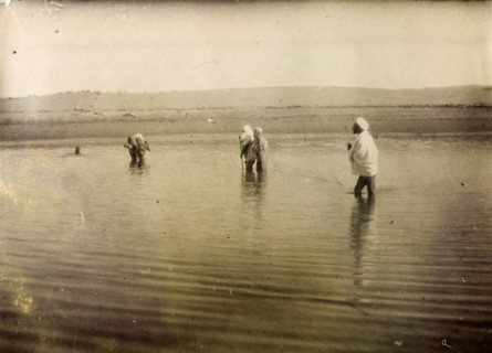 Fishing in south Morocco. A group of Moroccan men stand up to their knees in water, holding a