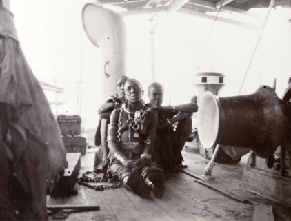 African woman convict on steamer deck. A semi-naked African woman sits on the deck of a steamer on