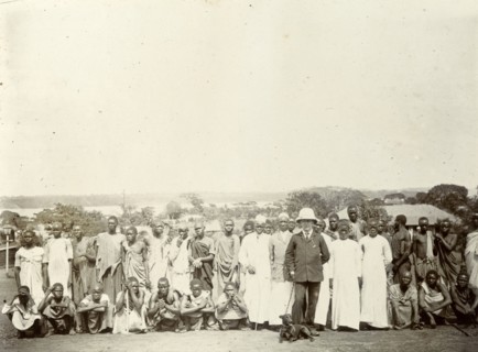 Tsetse fly researchers. A European official poses with Africans in a variety of costumes. A caption