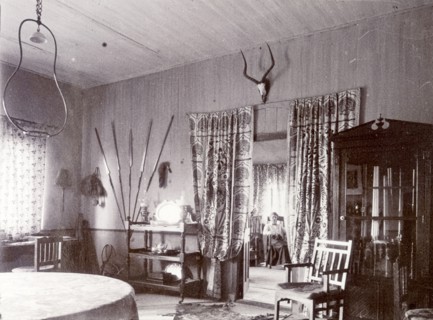 Mrs H' in the drawing room. A European woman identified as 'Mrs H', is seated in her drawing room,