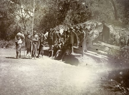 Kenyan 'road-makers'. A group of Kenyan men await instructions. They wear traditional dress and are