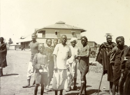 Kenyan men at the station. Local Kenyan men and boys gather for the camera outside a railway