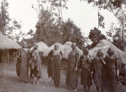 Kikuyu women in a village. Seven Kikuyu women pose for their photograph in front of their round,