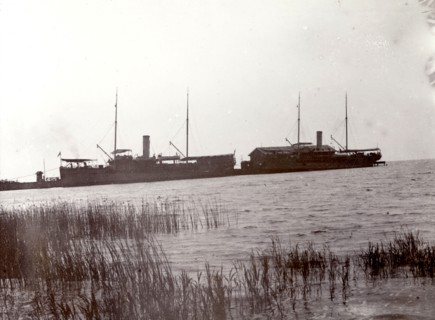 Lake steamers on Lake Victoria. The masts and funnels of two large lake steamers are silhouetted