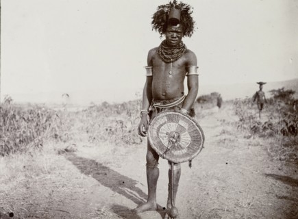 Medicine man, Kenya. Full-length portrait of a man identified in the original caption as a 'witch