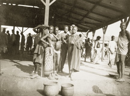 Grain traders in the market at Kisumu. African men and women stand beneath a modern market canopy: