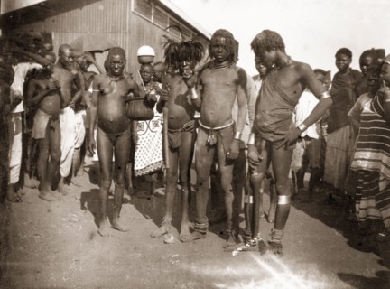 Luo youths at Kisumu market. A group of African youths, probably Luo, gather outside a local market