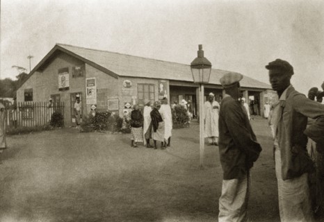 Jos railway station. African men and women mill around on the street outside Jos railway station.