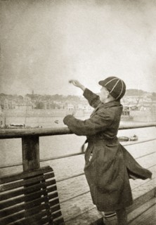 Charles Trotter on a pier. Charles Trotter, aged about 12 years old, throws pebbles into the sea