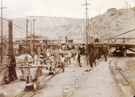 Premier Diamond Mine. African mine workers and a European overseer on the loading railway at the