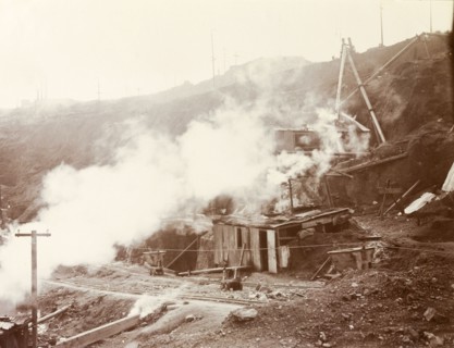 Pumps at the Premier Diamond Mine. Makeshift huts, possibly pump houses, are enveloped in steam at