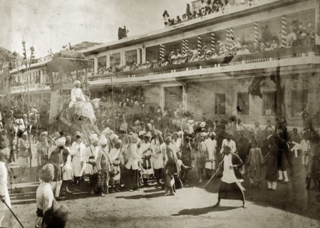 Religious parade, India. Europeans line the upper balconies of a city street to watch a religious