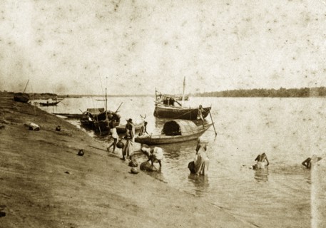 Washing in the River Ganges. People wash themselves in the River Ganges beside several small