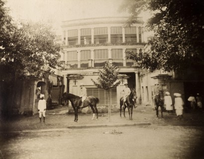 Saddling up outside a colonial house. S.A.H. Sitwell and friends pose on horseback in the walled