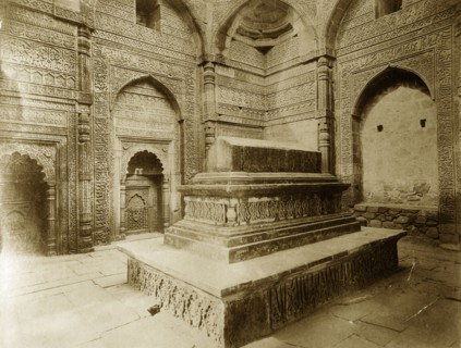 Tomb at Qutb Minar, Delhi. Intricately carved stone walls surround a tomb located inside the Qutb