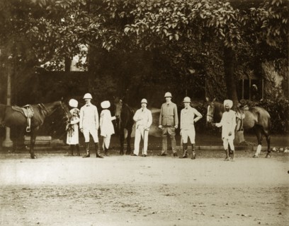 British men with Indian servants. Four British men pose for the camera, their Indian servants