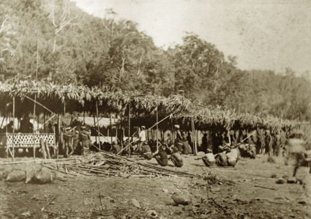 Chin tribesmen, Burma (Myanmar). A group of Chin tribesmen from the Chin Hills crouch beneath a