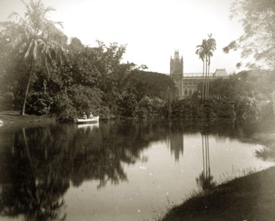 Afloat in the Eden Gardens. A couple in a rowing boat glide across the still waters of a pool in