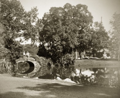 Burmese pagoda in the Eden Gardens. Two people chat on a footbridge leading to the Burmese pagoda