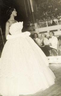 Carnival Queen beauty pageant. A contestant in a beauty pageant turns to smile at a panel of judges