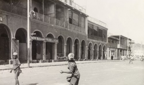 Rioting in Aden, 1947. A man takes aim in throwing an object at a bazaar in Aden, during the Arab