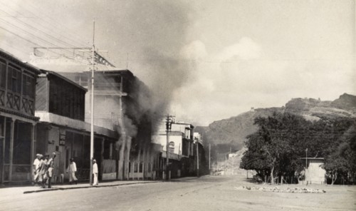 Riot damage in Aden, 1947. Smoke billows from a building in the Jewish quarter of Aden, during the
