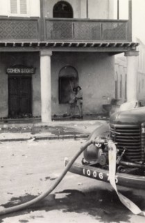 Fire fighters in Aden during the Arab riots, 1947. Two fire fighters extinguish a fire in 'Cohen