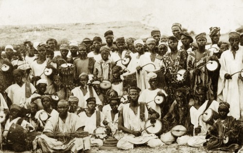 Tom-tom drummers. A group of dancers and tom-tom drummers pose for the camera holding curved