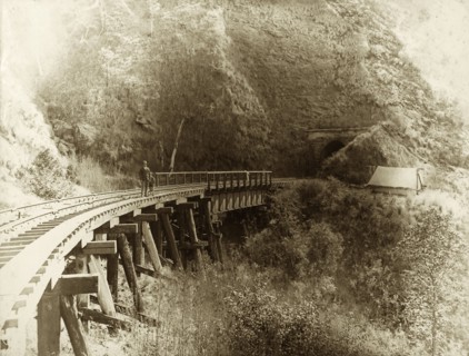 Railway bridge, Queensland. A man and young boy stand on a railway bridge cut into the side of a