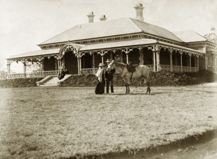 House called 'Wyalla', Australia. A couple with a saddled horse stand on the lawn at 'Wyalla', a