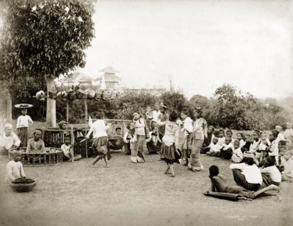 Children perform a 'pwe'. Several young girls perform a 'pwe' (Burmese dance drama) surrounded by a