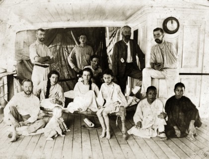 Survivors from SS Aden. Twelve men, women and children in informal dress pose on the deck of a ship