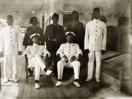 Engine room officials. Group portrait of six uniformed engineer room officials posed on the deck of