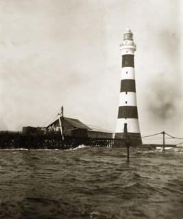 Alguada Reef lighthouse. The striped Alguada Reef lighthouse towers above rough sea waters in the