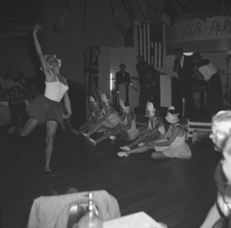 A graceful leap. One of several men dressed as ballerinas leaps gracefully across the floor as the