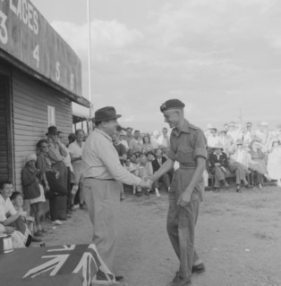 Handshake at the Nakuru Races. A young man wearing military uniform and beret shakes hands as he