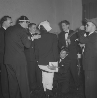 Rugby team antics. Members of a rugby team dressed in tuxedos fool around at the Mogambo Club. Two