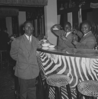 Bartenders at the Equator Club. Portrait of three uniformed waiters at the Equator Club. Two