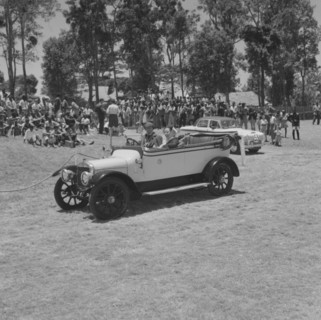 Austin convertible. A couple drive a Austin convertible car past onlookers in a vehicle parade at