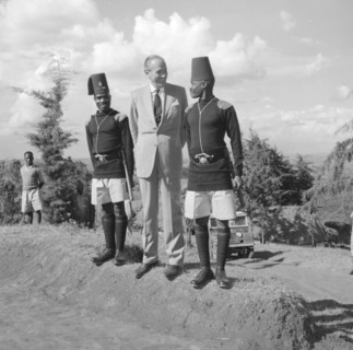 Lennox-Boyd jokes with askaris. Alan Tindal Lennox-Boyd (1904-1983) jokes with two uniformed