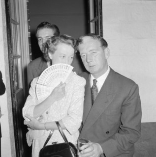 Prudential Insurance cocktail party. A woman whispers discreetly to her partner at a Prudential