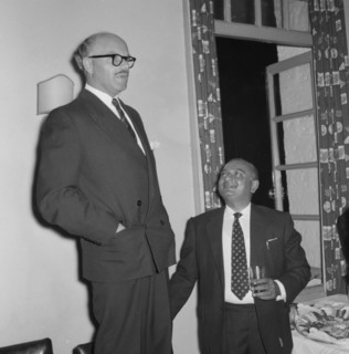 Prudential Insurance cocktail party. A suited businessman stands on a chair to deliver a speech at