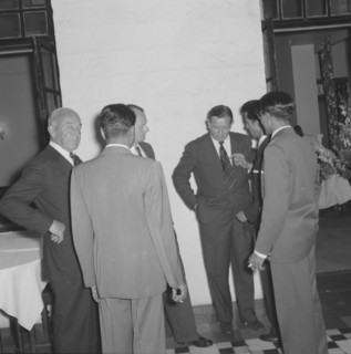 After dinner conversation. A group of suited businessmen huddle together, deep in discussion, at a